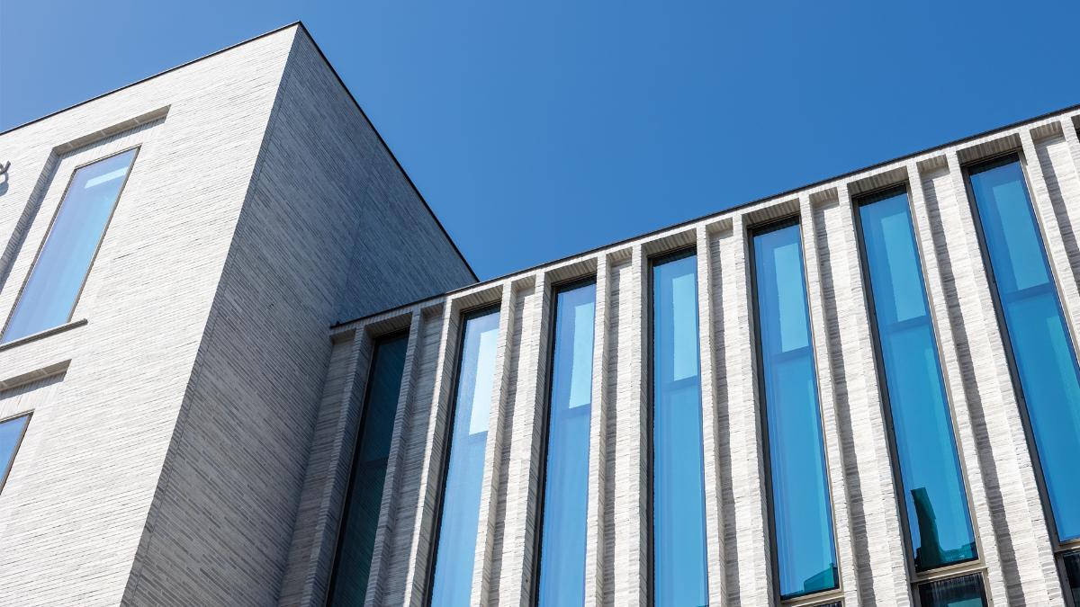 Close-up of the building, light brick and glass surfaces.