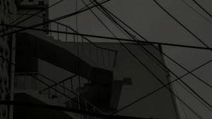 Tumma kuva rakennuksesta, jossa portaikko ja sähköjohtoja