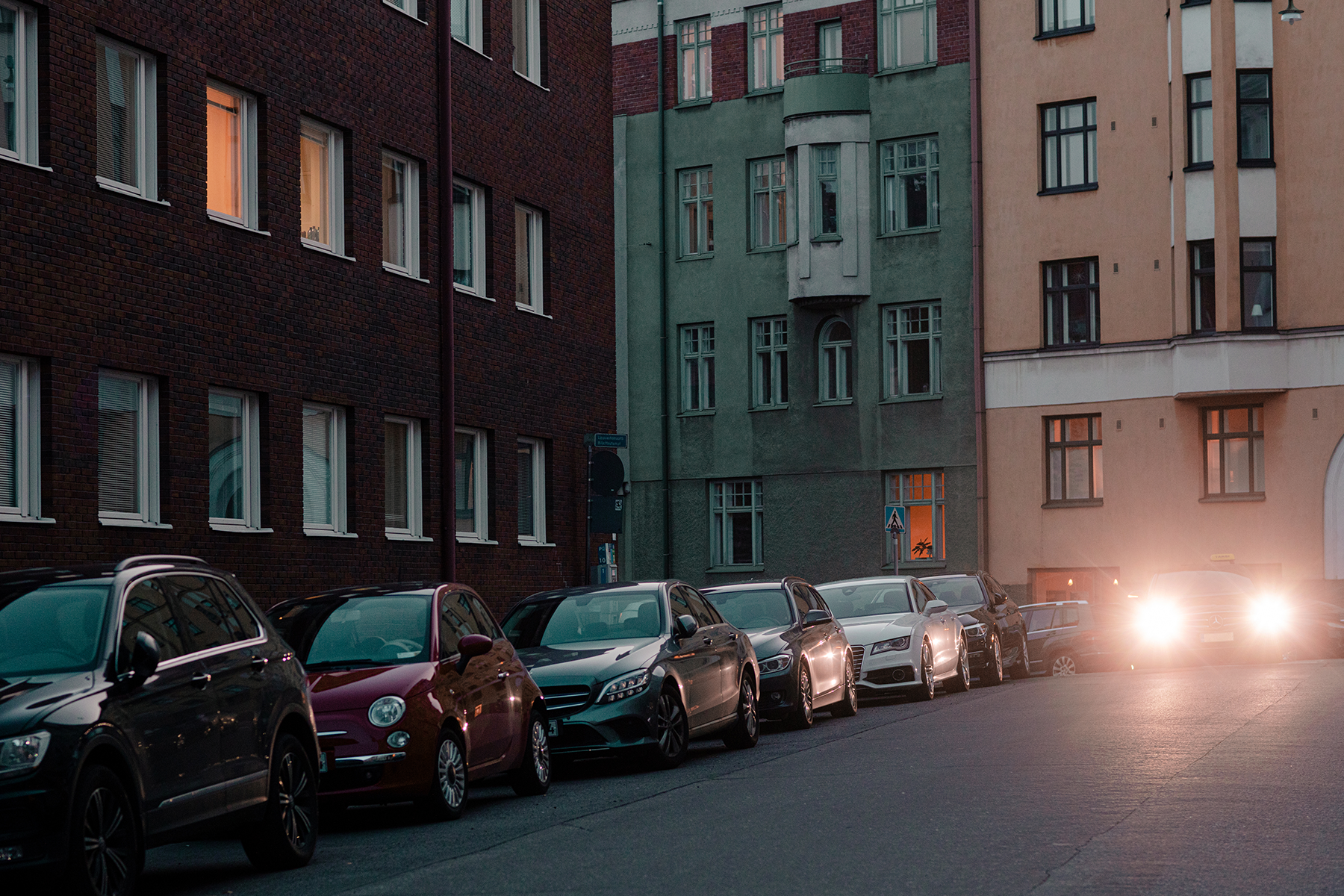 Illustration - a street view by night fall with parked cars. 