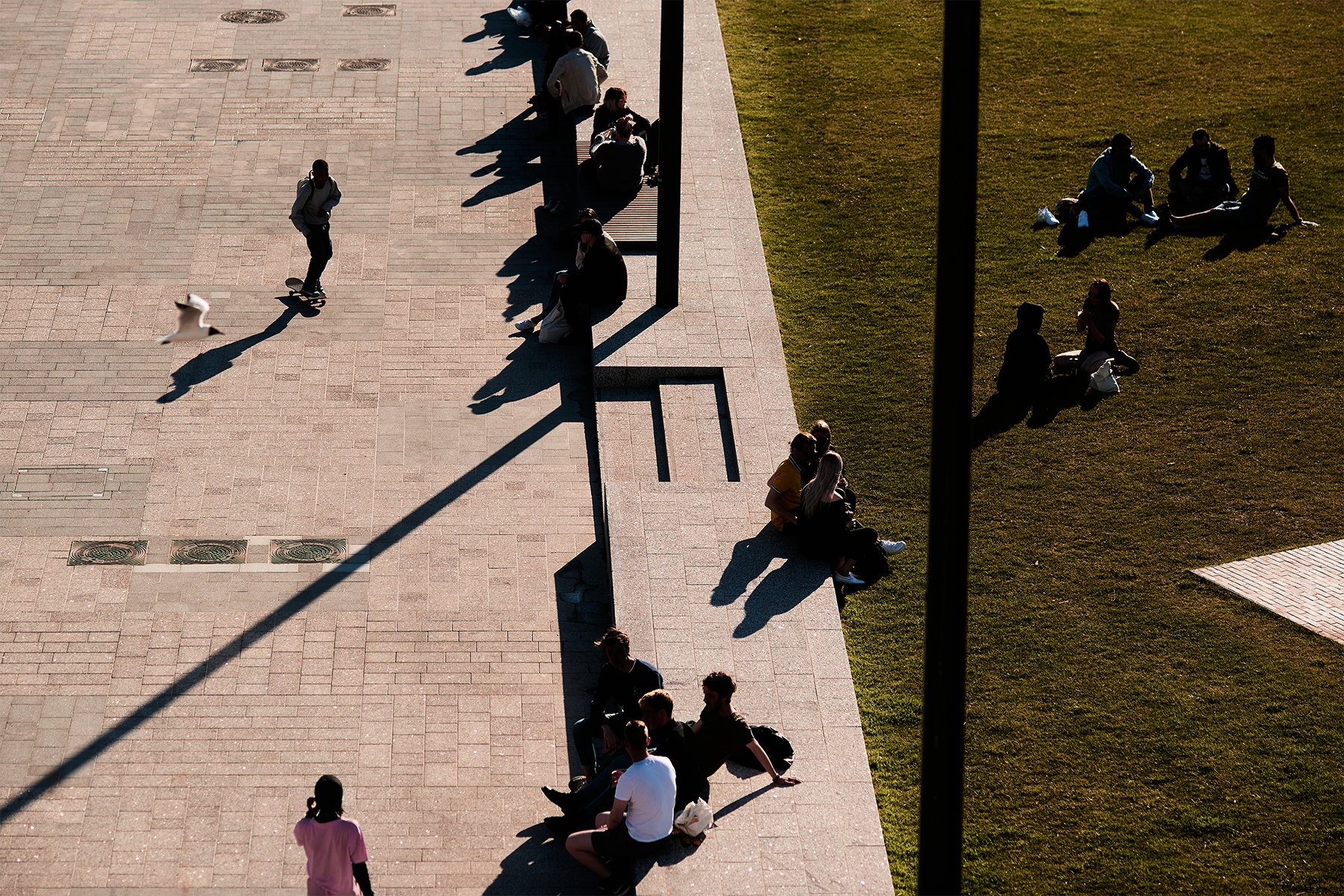Illustration - people sitting on a bench as dark silhouettes in a park.