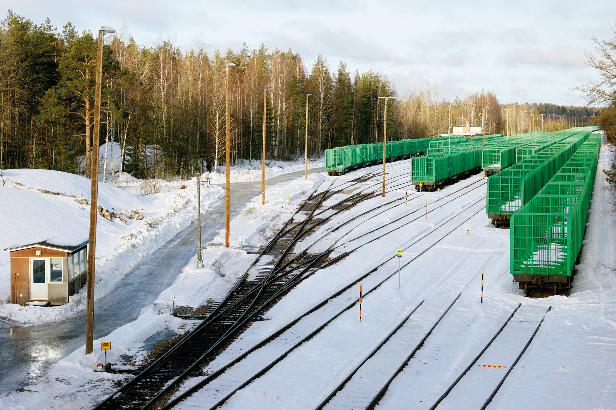 Green railroad cars on tracks.